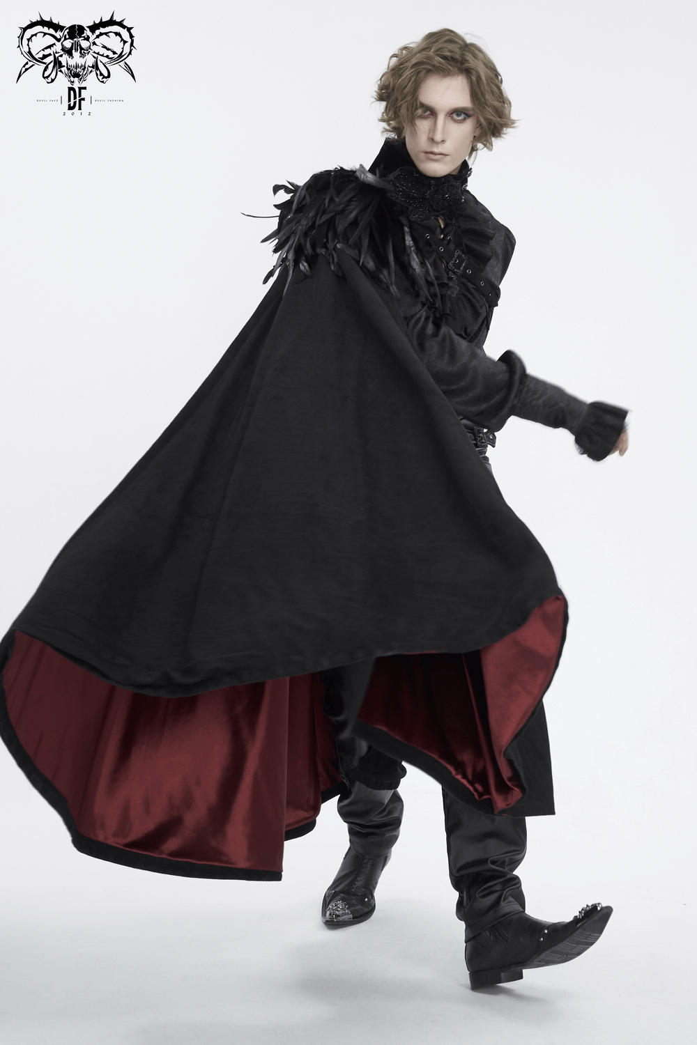 Bold model wearing a feathered black asymmetric cape with rich red lining, perfect for evening glam and making a fashion statement.