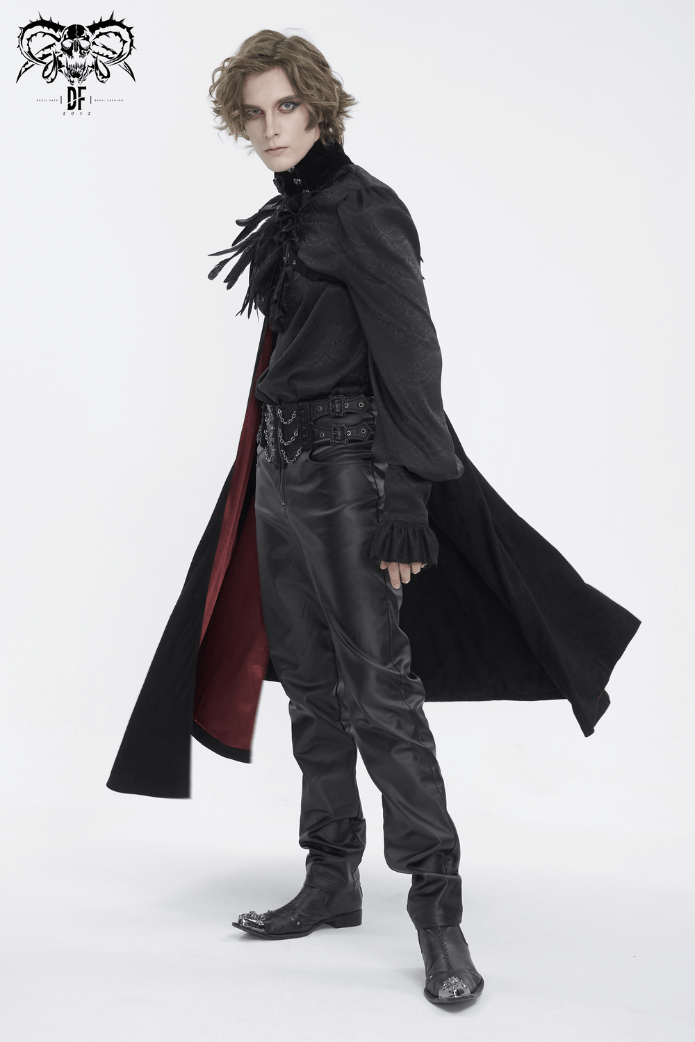 Chic model in black asymmetric cape with feather accents, posing for a dramatic evening look.