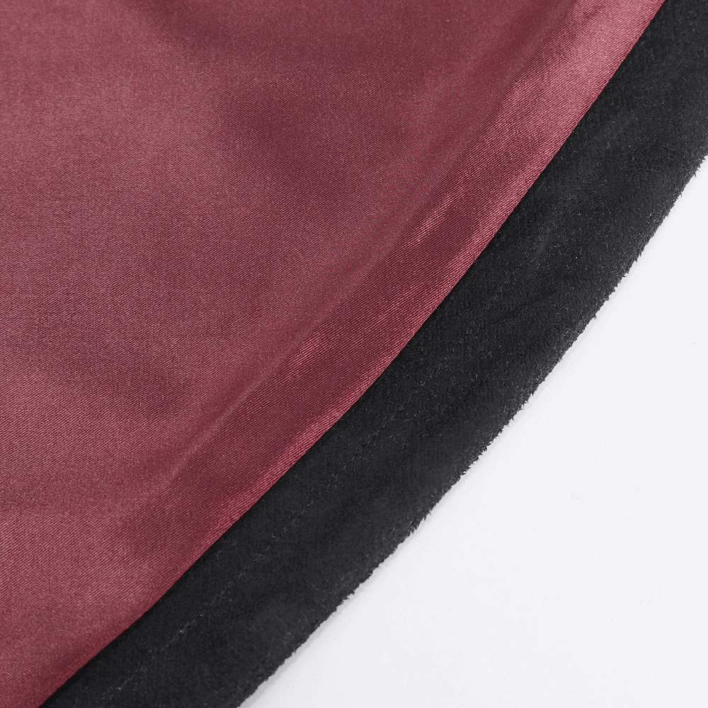 Close-up of burgundy and black fabric showing texture and color details of a stylish cape.