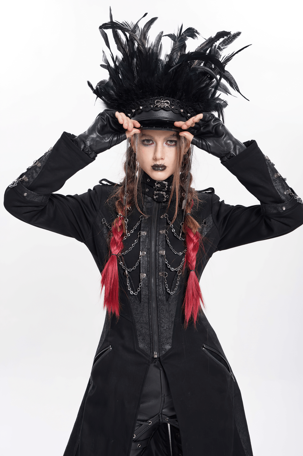 Gothic leather cap with feathers, lace, and chains, styled by model in dark attire, showcasing alternative fashion.