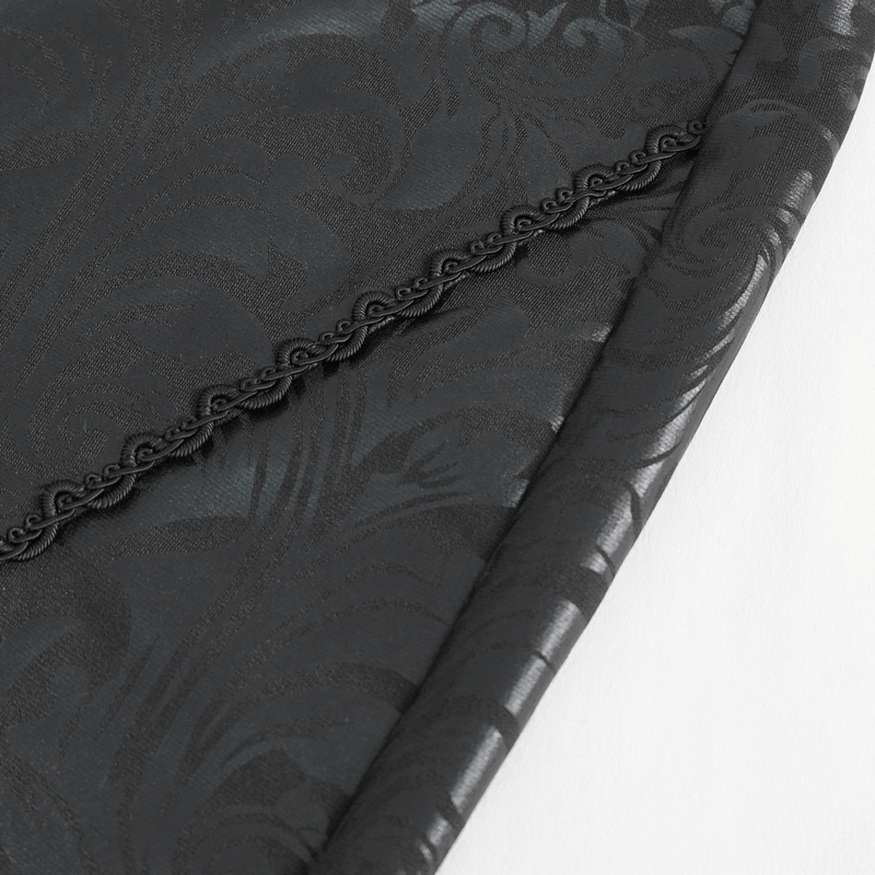 Close-up of luxurious black fabric with elegant damask pattern and delicate trim.