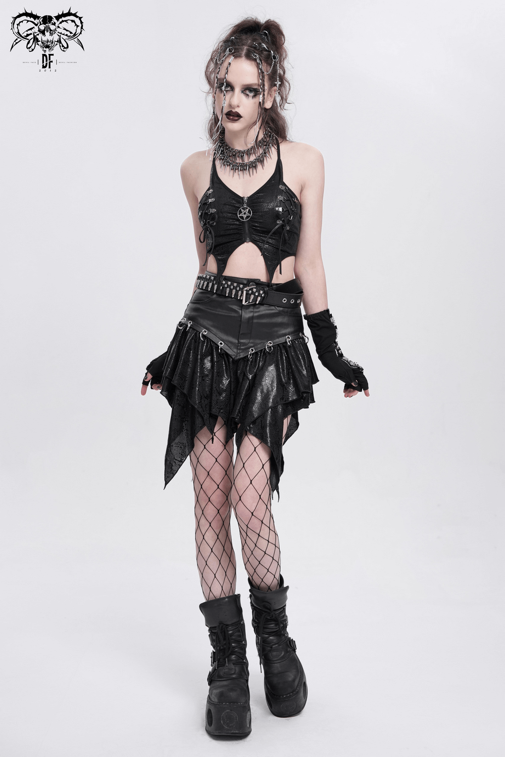 Edgy female model in a sleeveless black crop top with pentagram charm and layered skirt, showcasing punk style fashion.