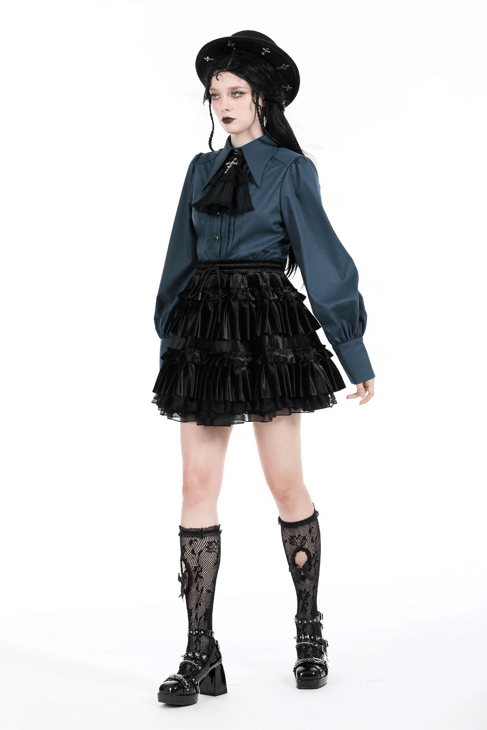 Stylish model in a frilly layered mini skirt and blue blouse, showcasing edgy goth fashion with lace details.