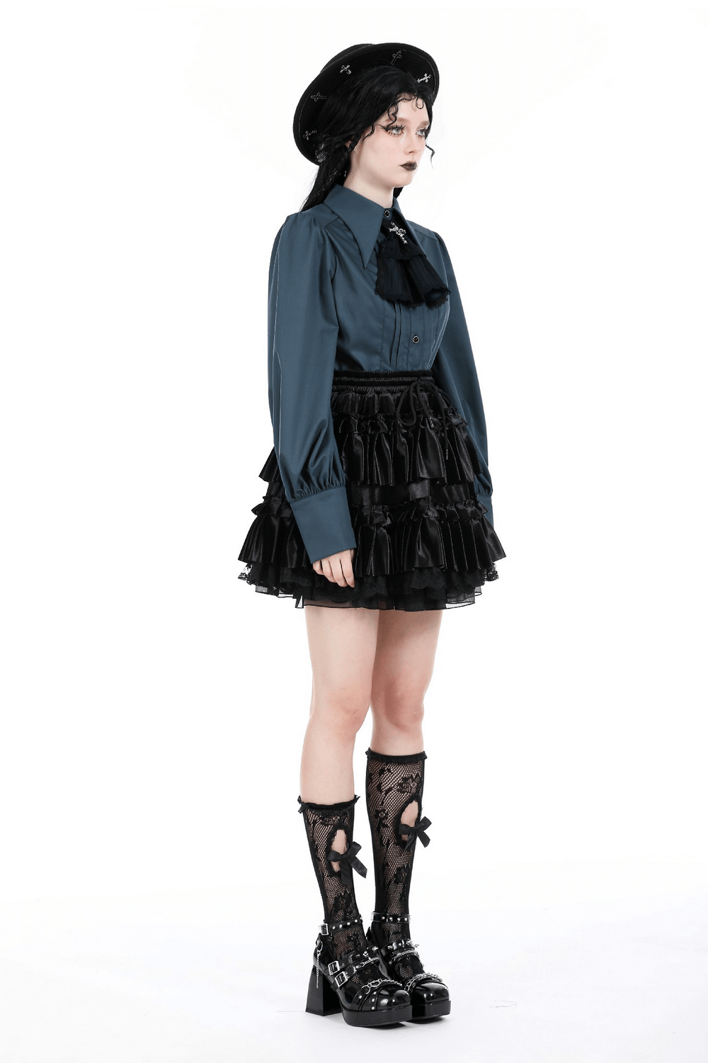 Stylish model wearing a frilly black layered mini skirt with lace trim paired with a blue blouse and elegant accessories.