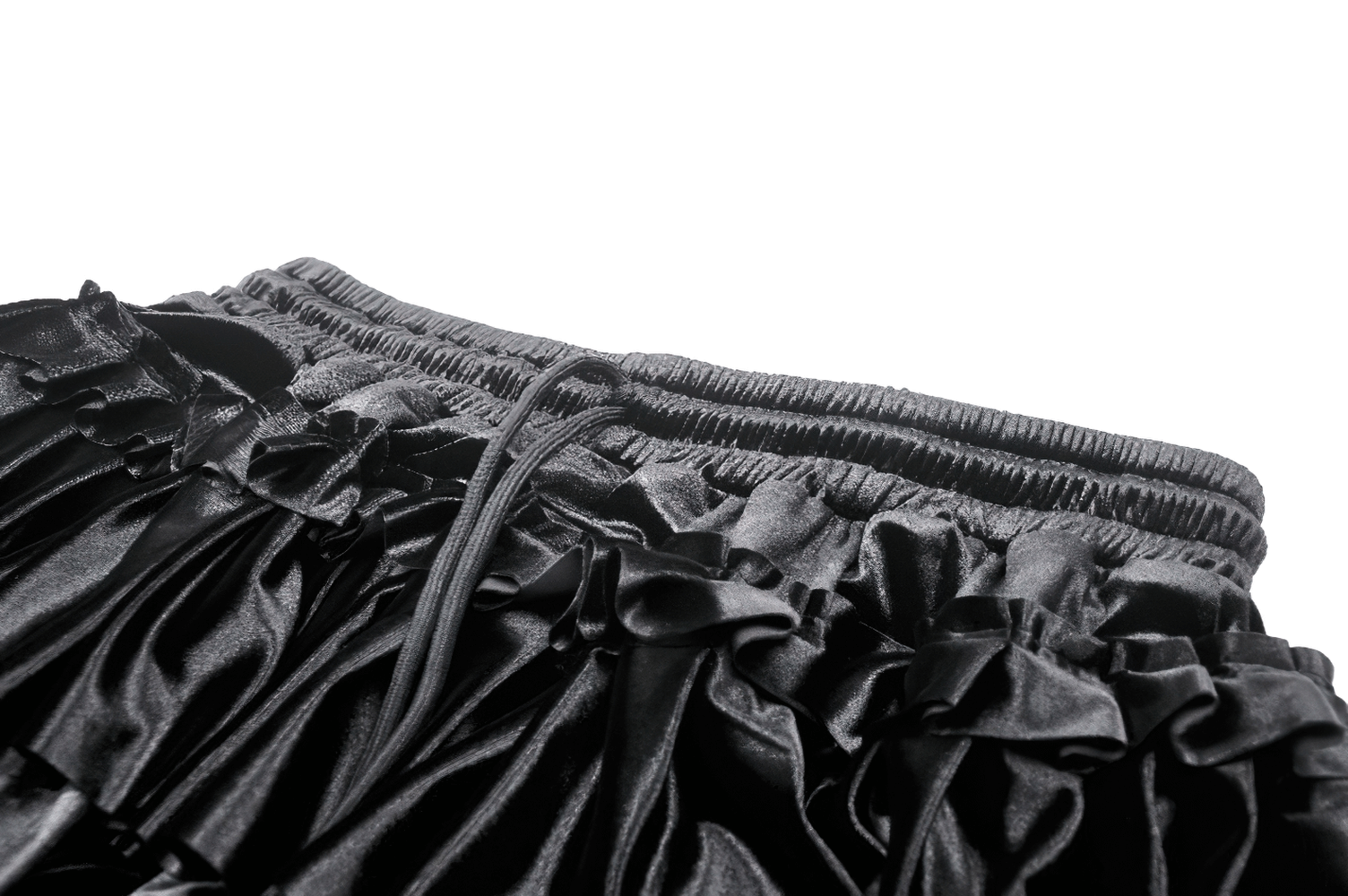 Close-up of a black frilly layered mini skirt with lace trim, showcasing a luxurious velvet texture and ruffled design.