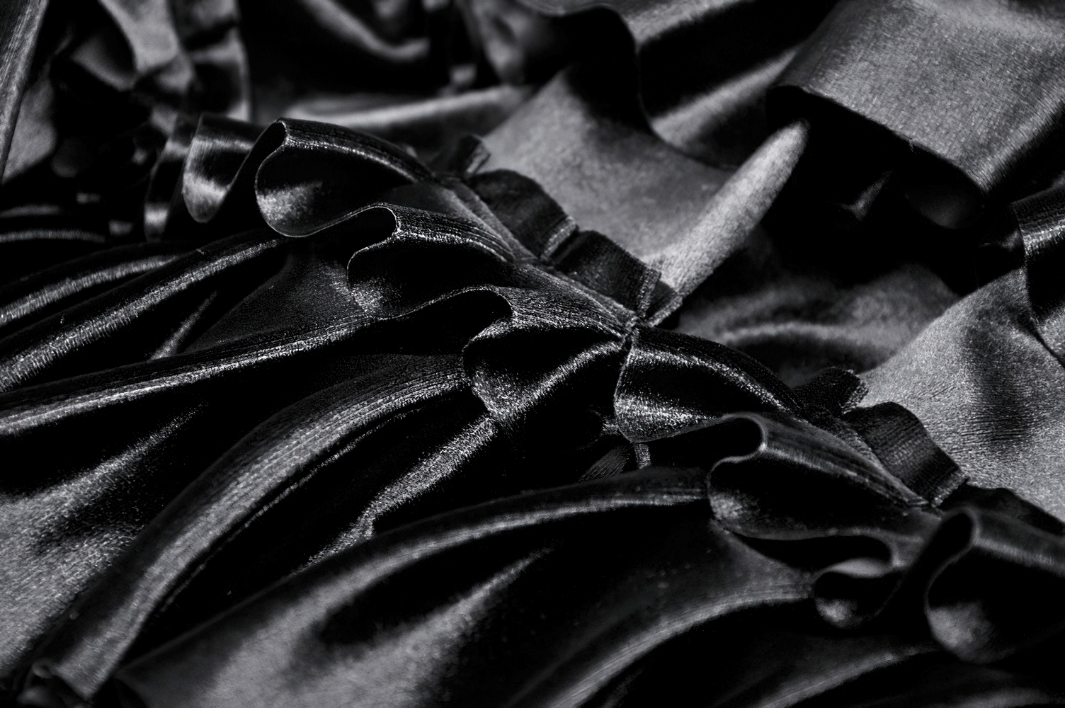 Close-up of luxurious black velvet fabric with layered ruffles and lace trim, perfect for a stylish mini skirt.