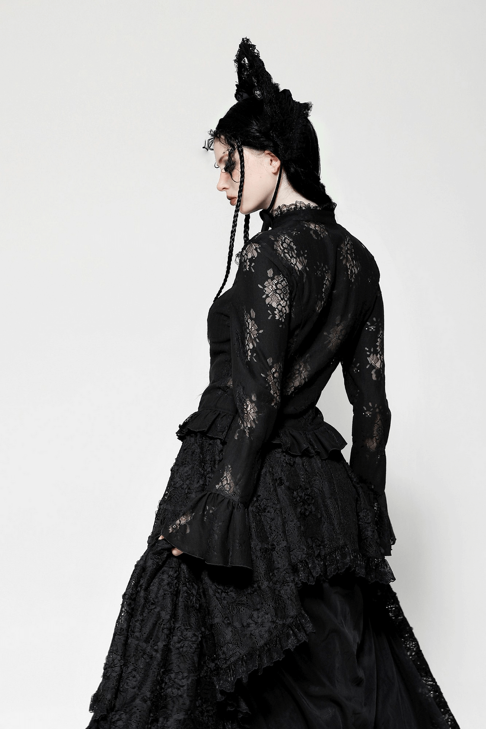 Black gothic lace blouse with bell sleeves and unique cutouts, styled for a mysterious look. Perfect for dark fashion enthusiasts.