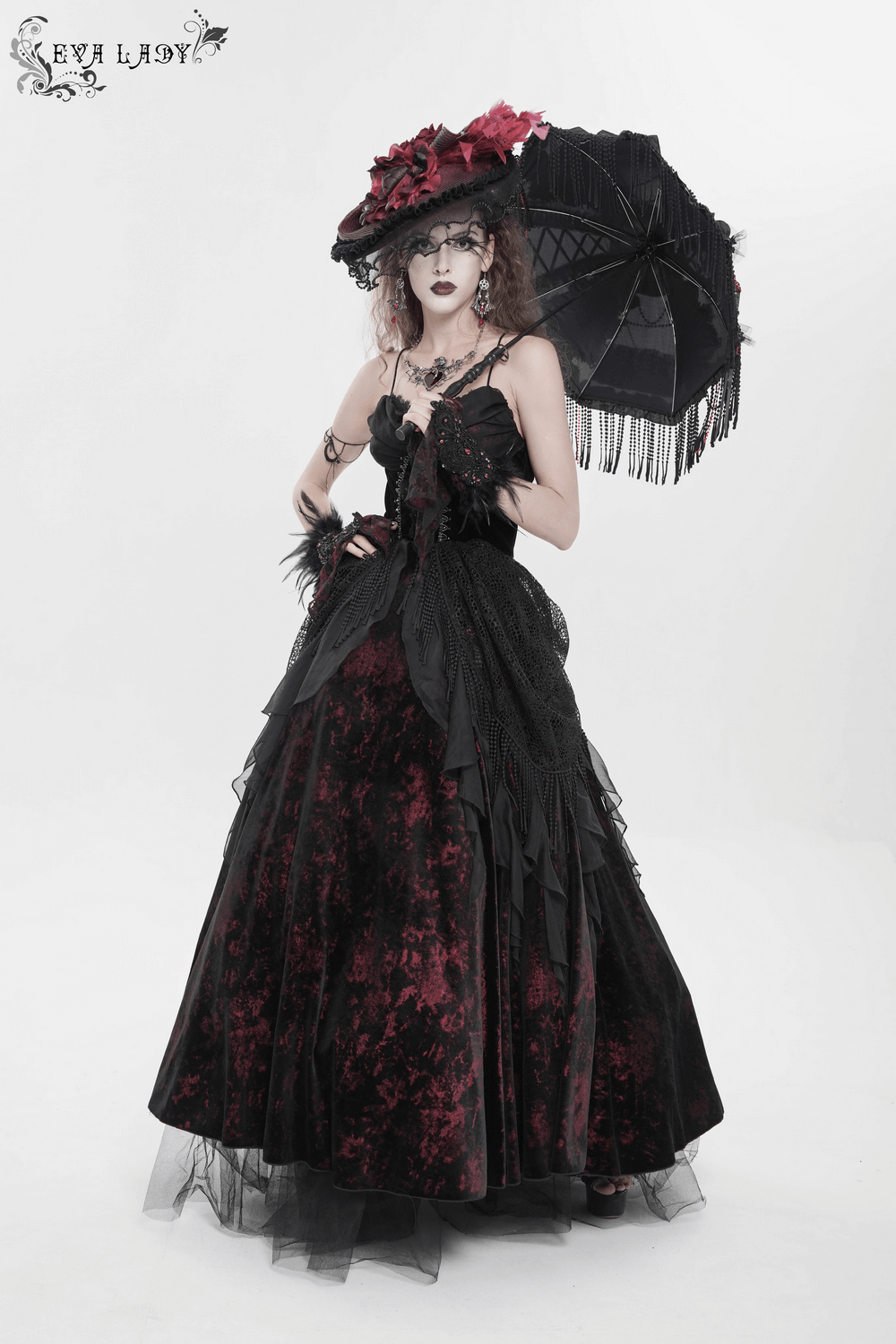Female Gothic Lace-Up Dress with Ruffled Tulle Layers worn by model with parasol and elaborate hat.