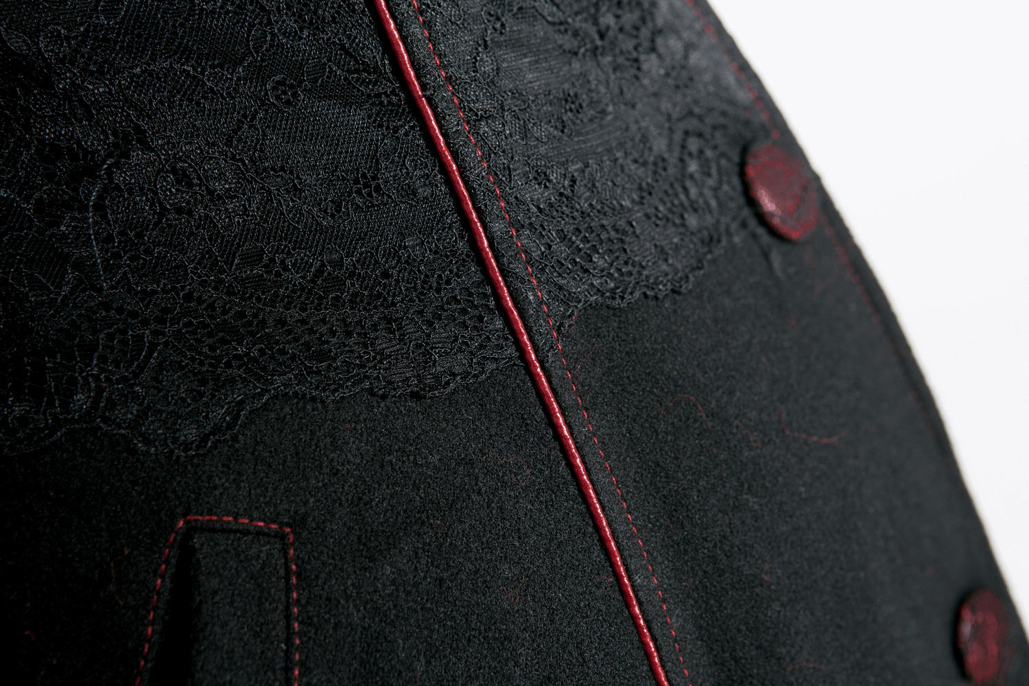 Close-up of female gothic long coat showcasing detailed lace and vibrant red trim.