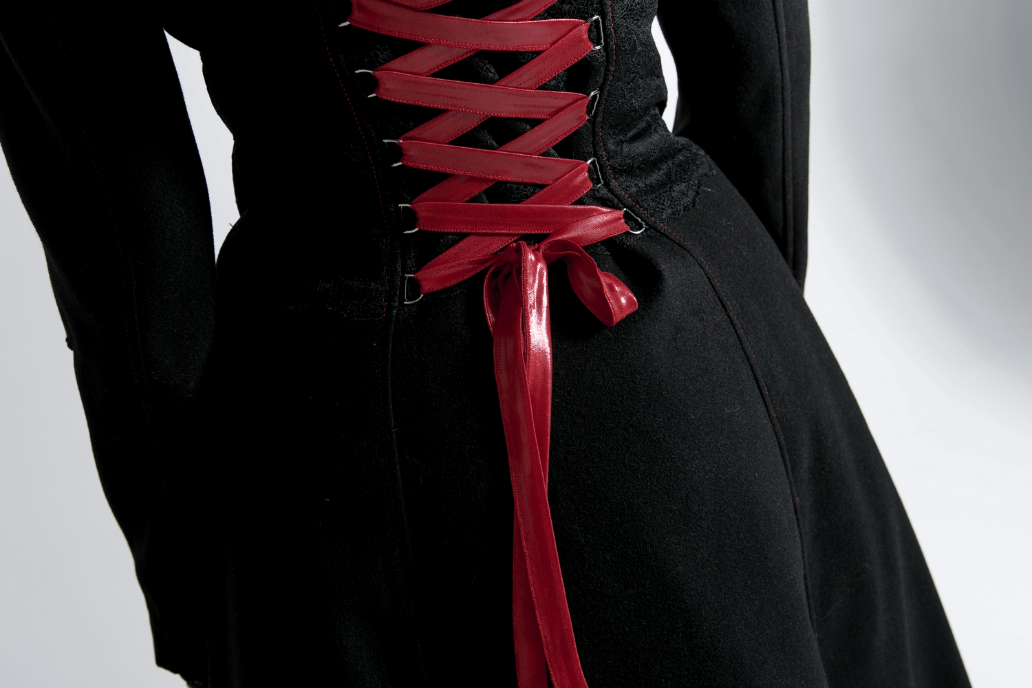 Elegant black long coat with red lace-up back detail, showcasing gothic style and dramatic flair.