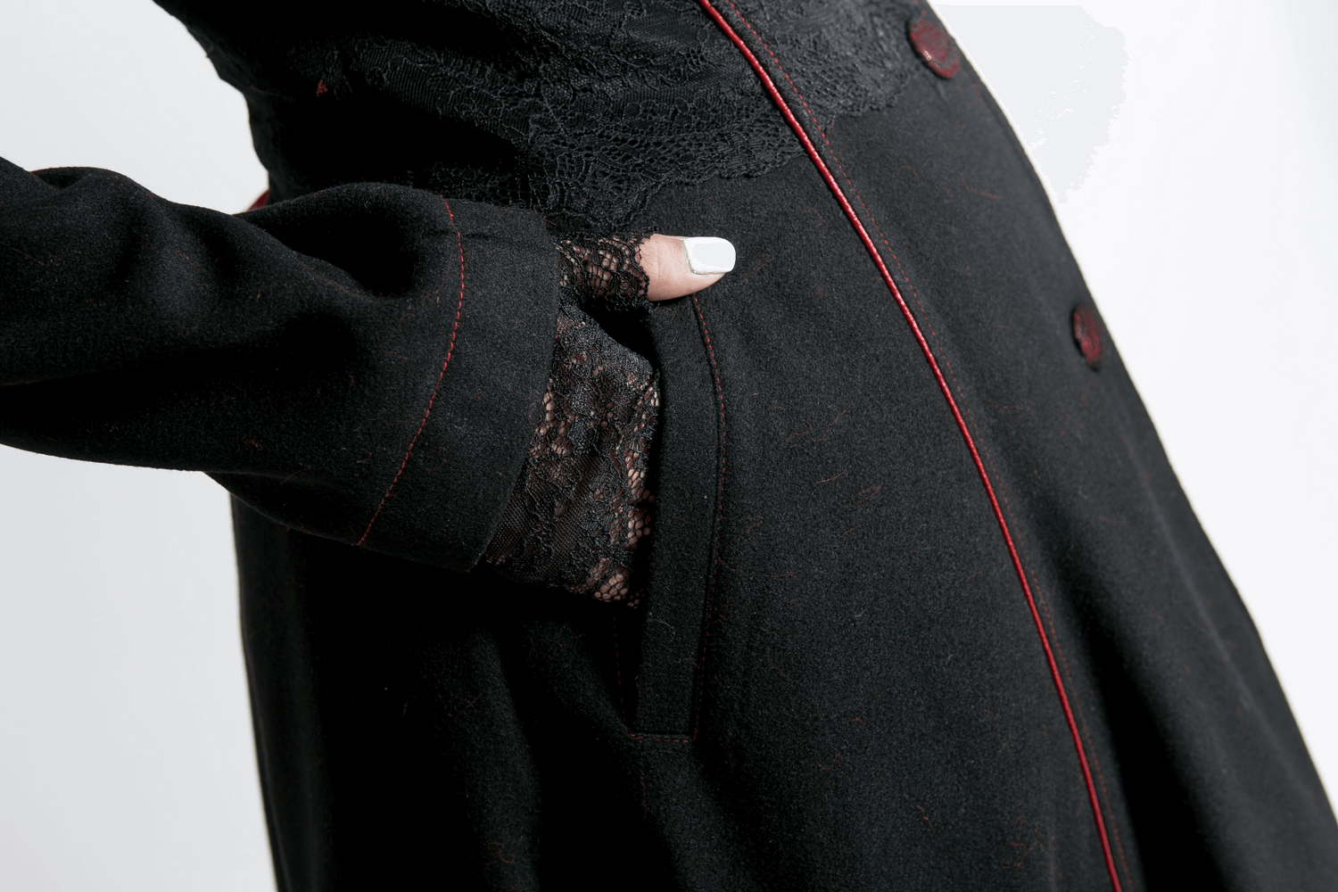 Close-up of female gothic long coat with red trim and lace sleeve, showcasing elegant design and functional pocket.