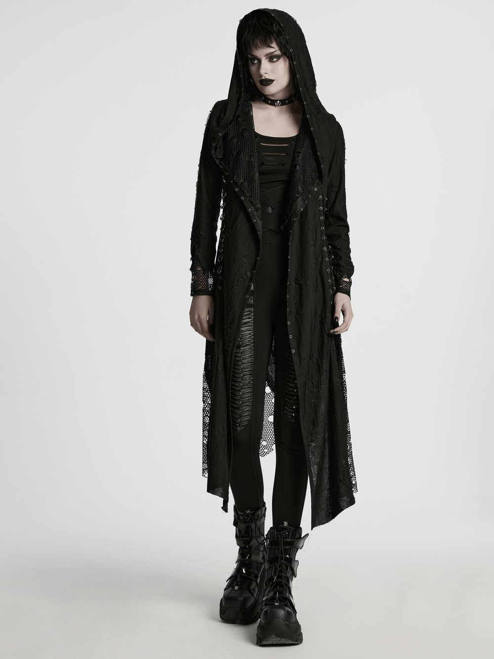 Female model wearing a gothic mesh and knit hooded asymmetric coat, styled with edgy makeup and accessories.