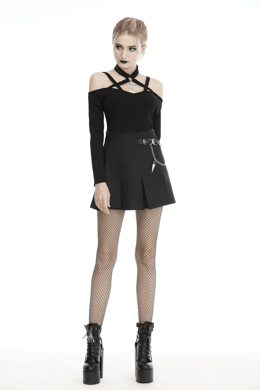 Edgy female model wearing a black pleated mini skirt with chain detail, showcasing gothic style.