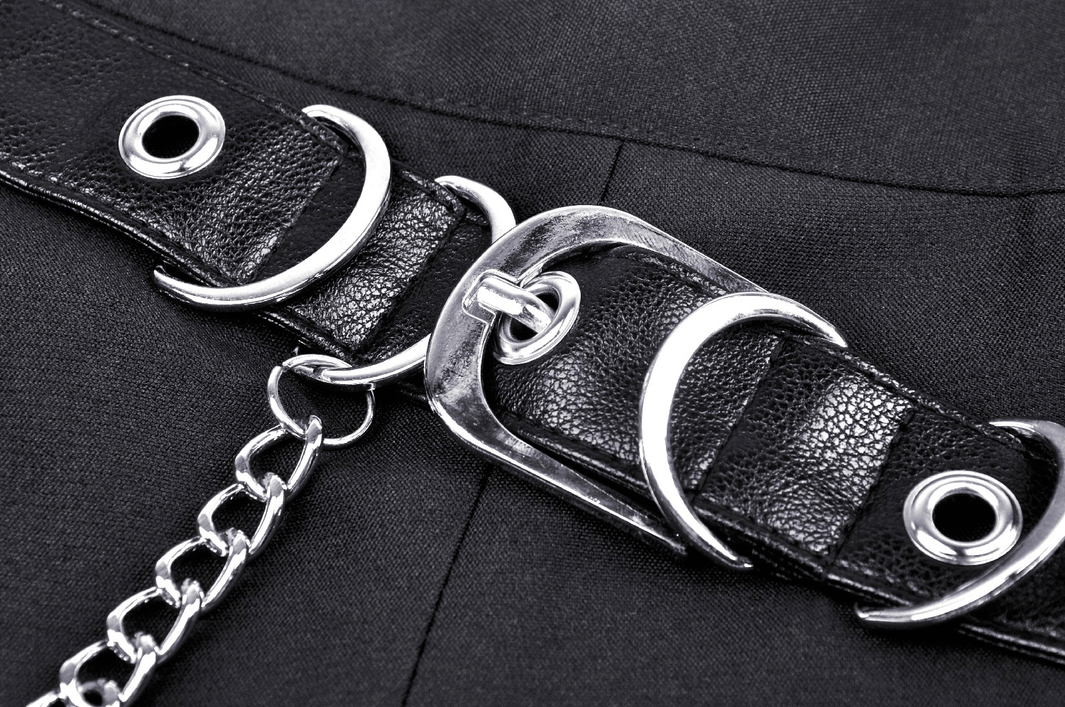 Close-up of the chain detail and buckle on a female gothic pleated mini skirt, showcasing edgy fashion.