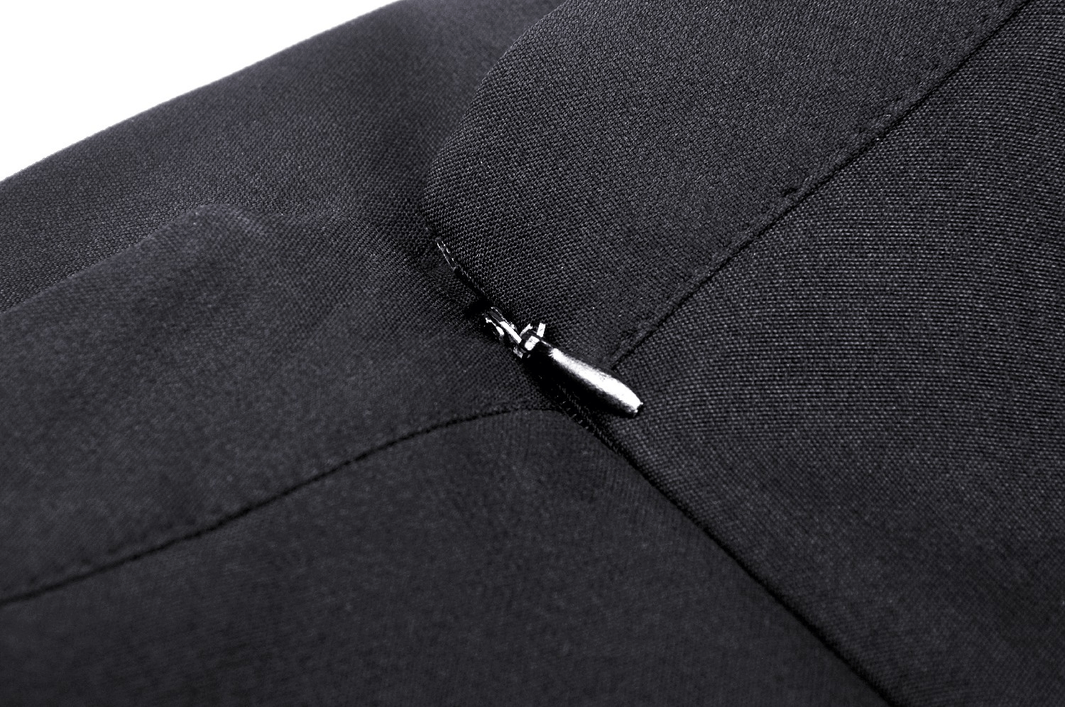 Close-up of the zipper detail on a black pleated mini skirt with gothic style.