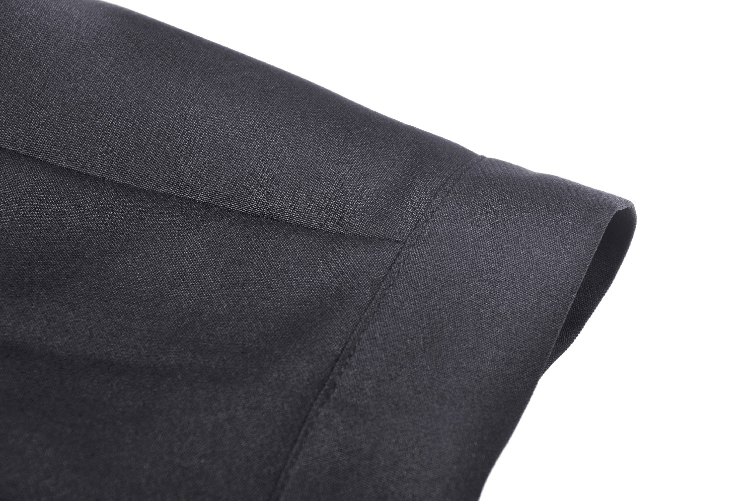 Close-up of the fabric detail of a black pleated mini skirt with smooth texture and clean lines.