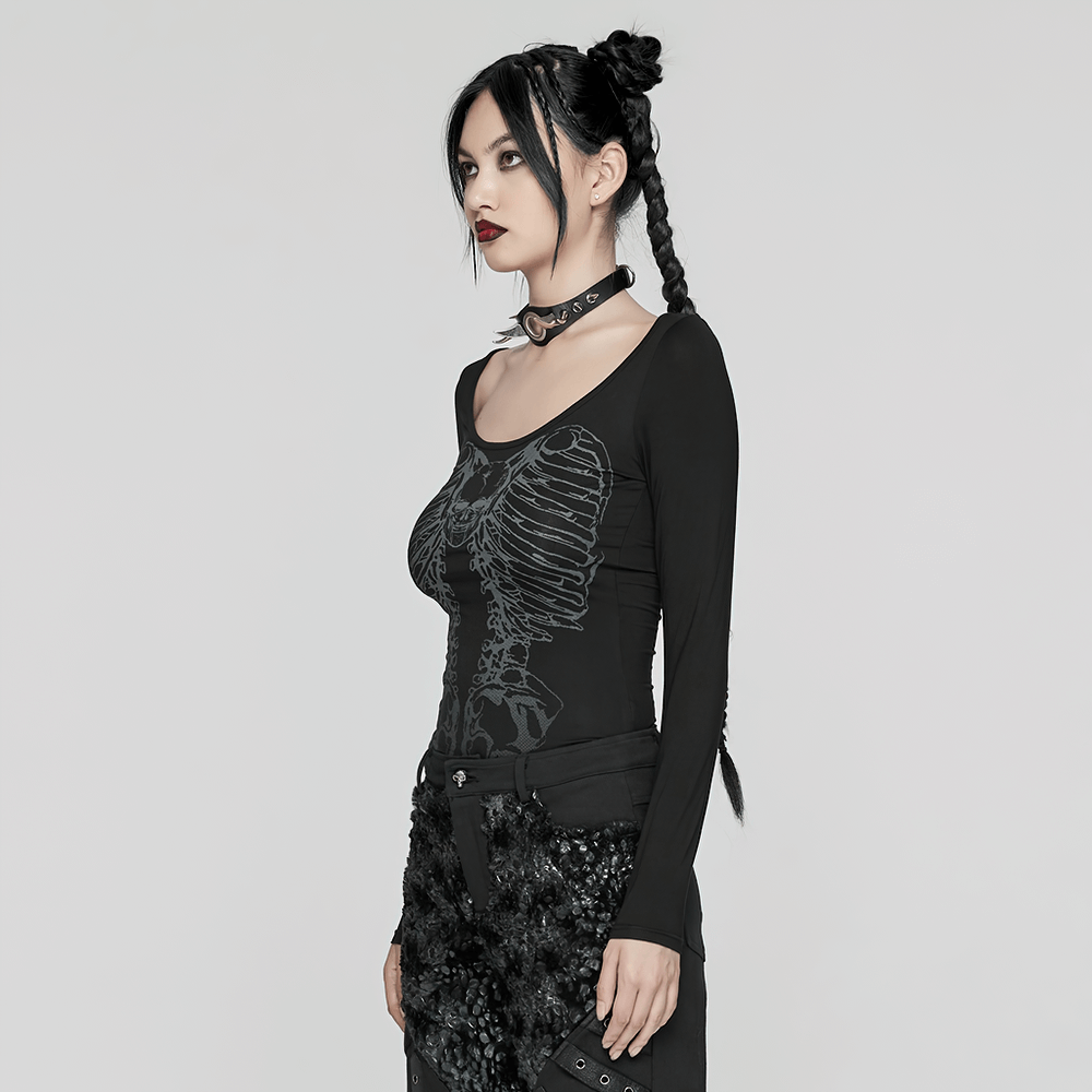 Gothic female model in a long-sleeved black top featuring a skeleton print and edgy chain details, styled with punk accessories.