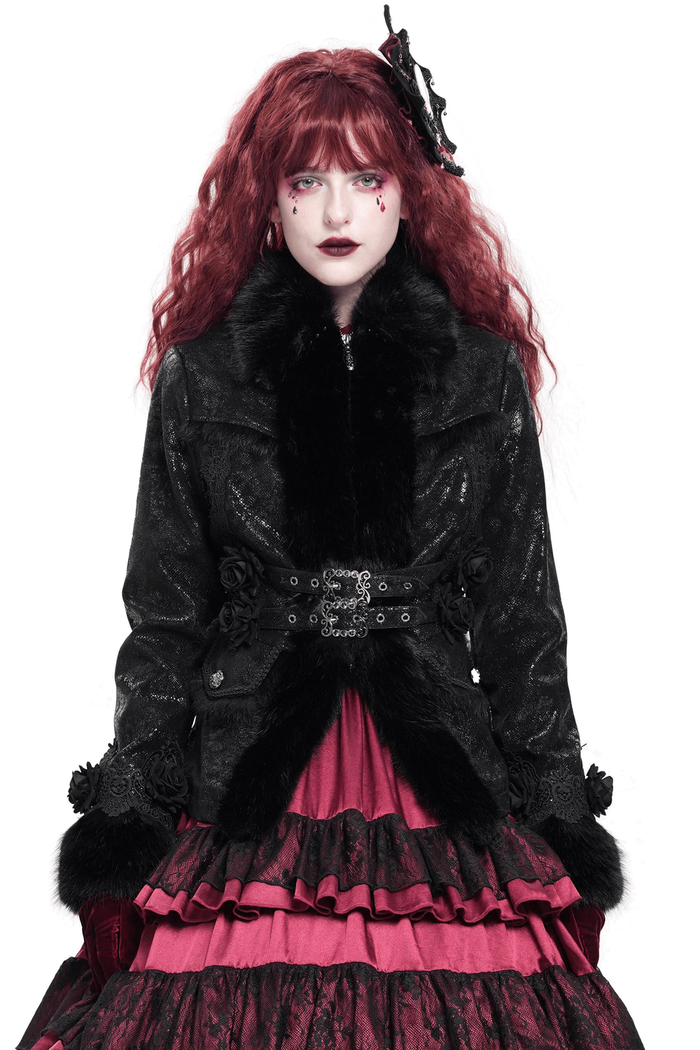 Gothic black jacket with faux fur trim, lace roses, and buckle strap details for women, styled with a pink skirt.