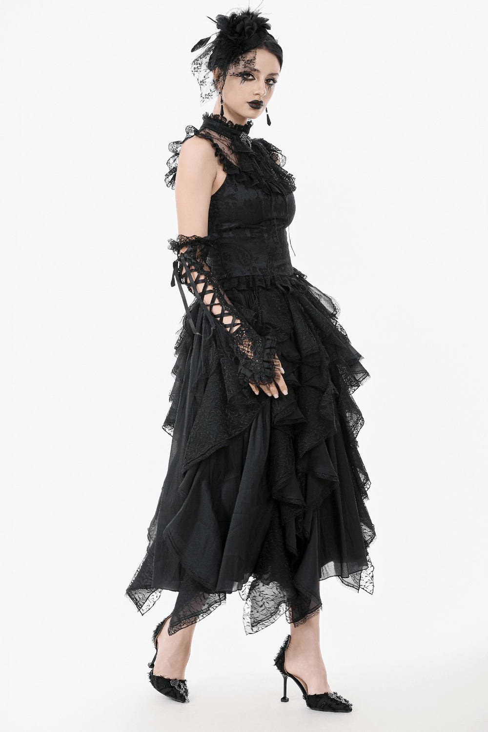 Elegant gothic model in black lace dress with frills, sheer sleeves, and corset back for dramatic flair.