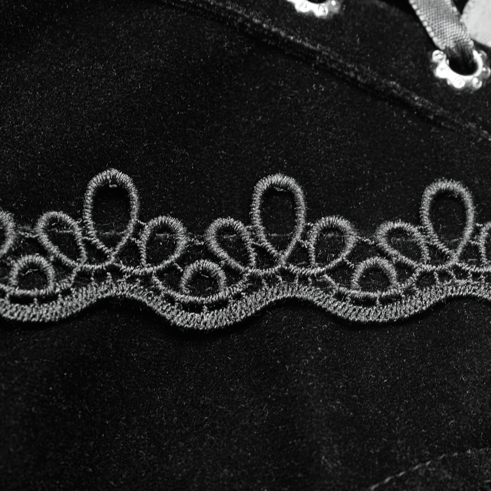 Close-up of intricate lace trim on stylish black fabric, adding gothic flair to the design.