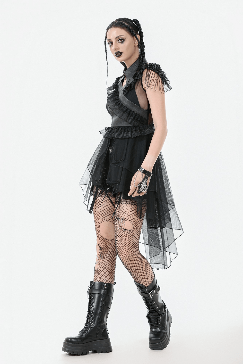 Gothic female model in a tiered black tulle dress with ruffles and lace-up back, paired with combat boots.