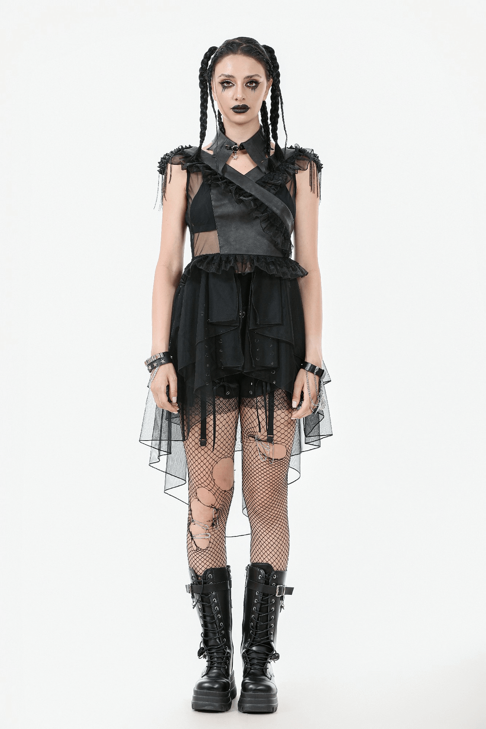 Gothic female model in tiered tulle dress with lace-up back, ruffled details, and edgy accessories.