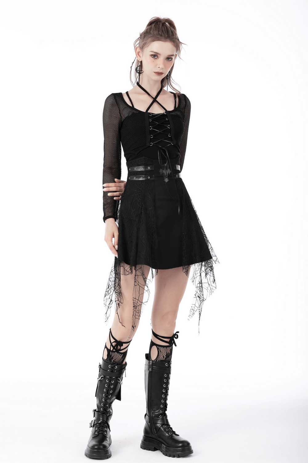 Edgy female model in sheer black mesh gothic crop top with long sleeves and stylish skirt, showcasing punk fashion.