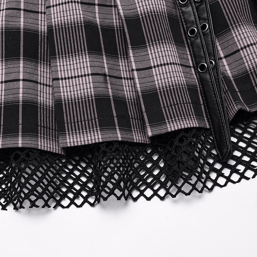 Close-up of black and pink plaid mini skirt with fishnet layered panel and faux leather accents.