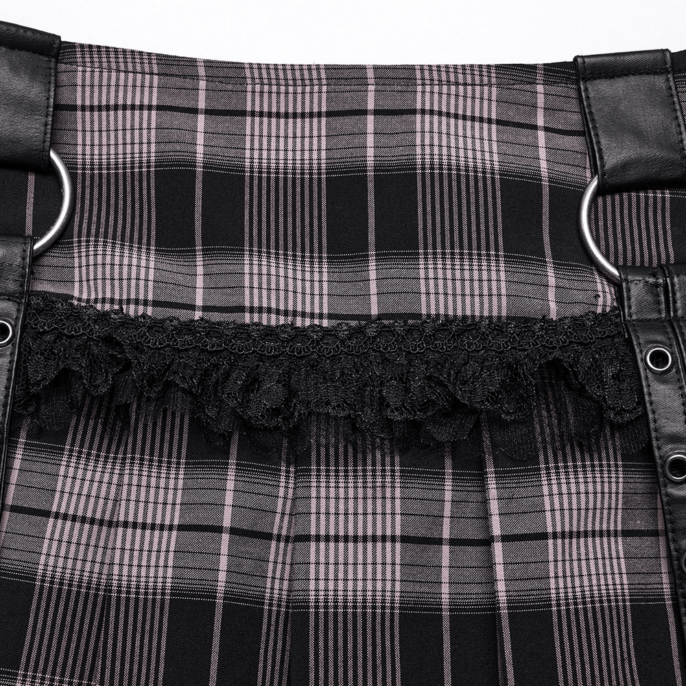 Close-up of black and pink plaid mini skirt with fishnet and faux leather details.