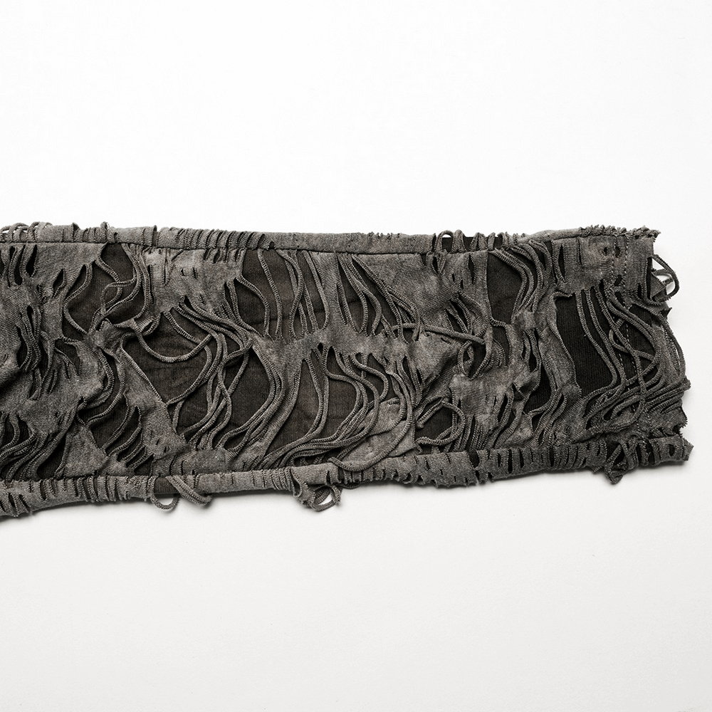 Close-up of ripped fabric with edgy tattered texture for punk style fashion wear.