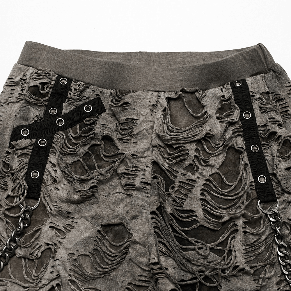 Female ripped skinny trousers with punk chain detailing, featuring tattered texture and unique elastic waistband.