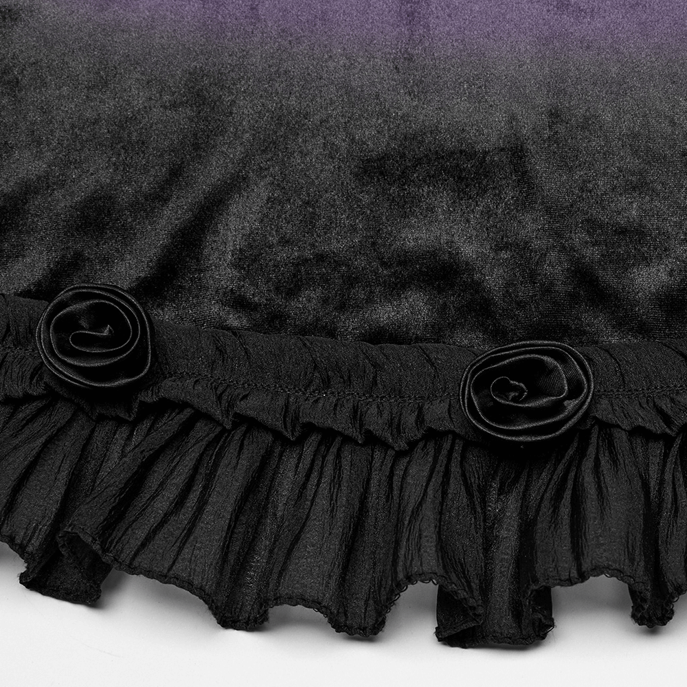Close-up of black velvet dress hem featuring ruffled lace with rose accents, highlighting gothic design elements.