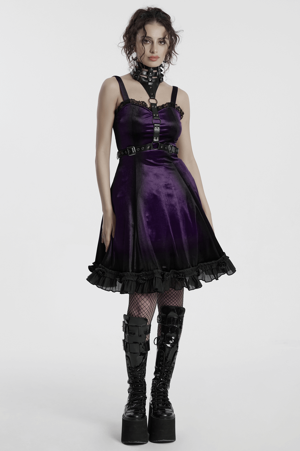 Gothic female sleeveless velvet dress in purple with lace ruffle hem, corset back, and striking platform boots.