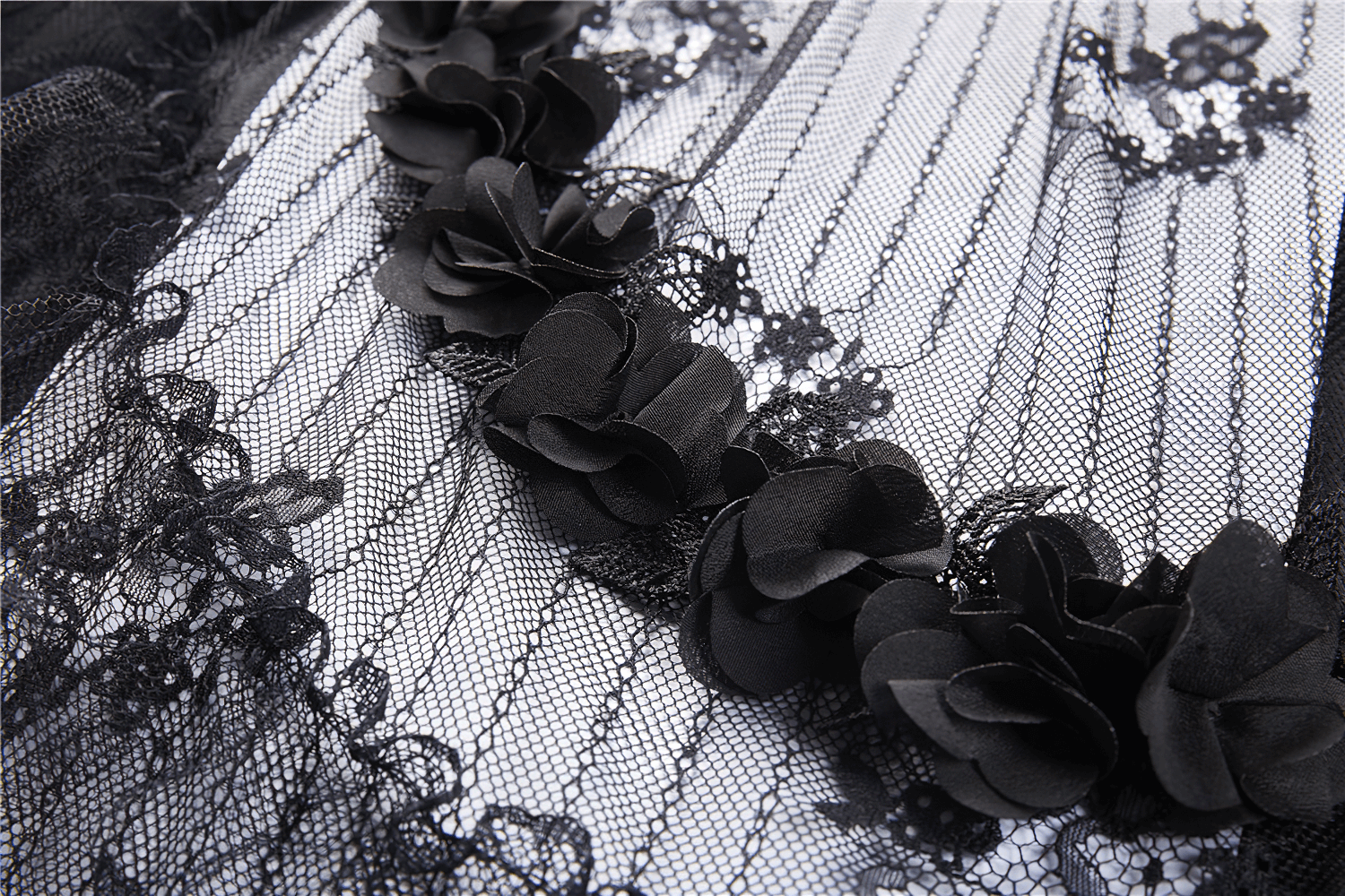 Close-up of elegant black lace trim adorned with decorative flowers on gothic fabric, perfect for stylish outfits.