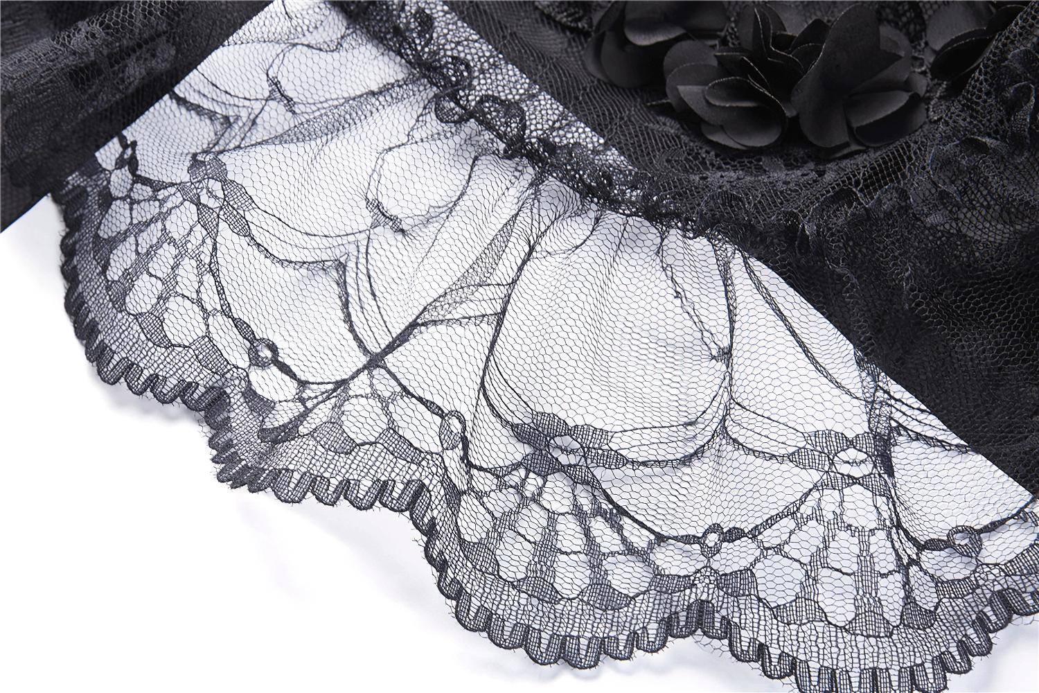 Close-up of exquisite black lace trim on a gothic velvet maxi skirt, showcasing elegant floral patterns.