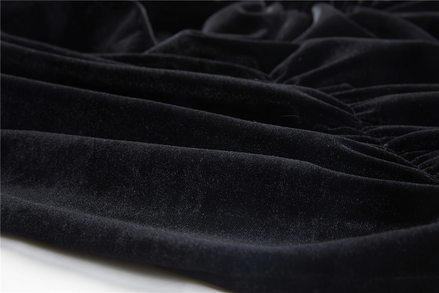 Close-up of luxurious black velvet fabric, showcasing smooth texture and elegance for gothic fashion.
