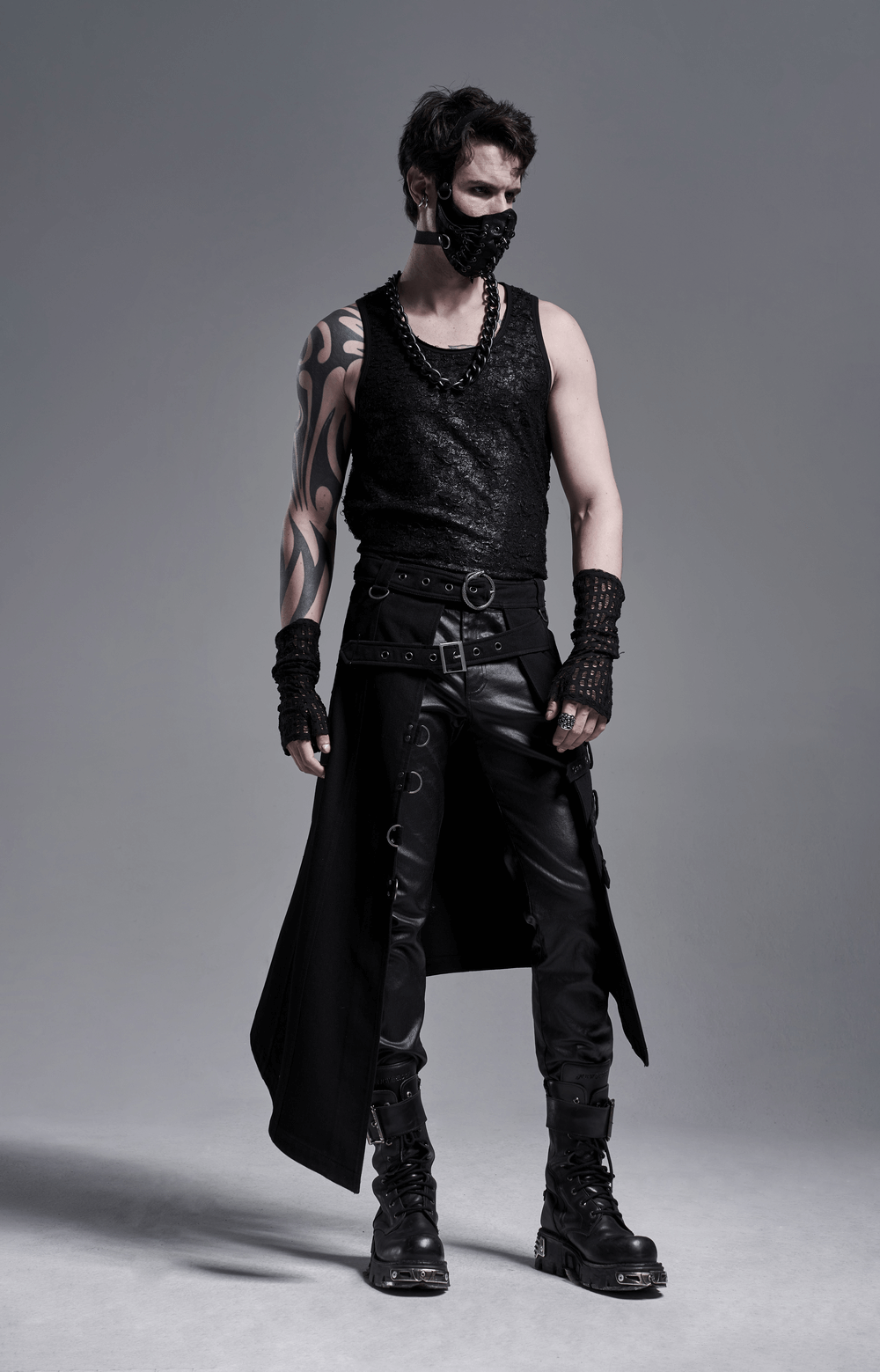 Edgy gothic style model wearing fingerless mesh gloves, black tank top, and leather pants.