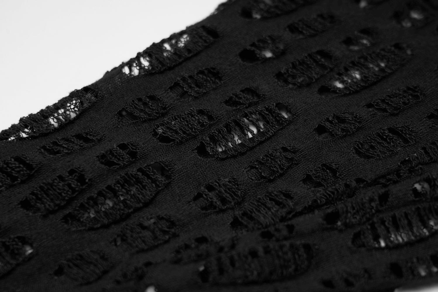 Close-up of intricate black mesh fabric showcasing a gothic fishnet design with edgy elegance.