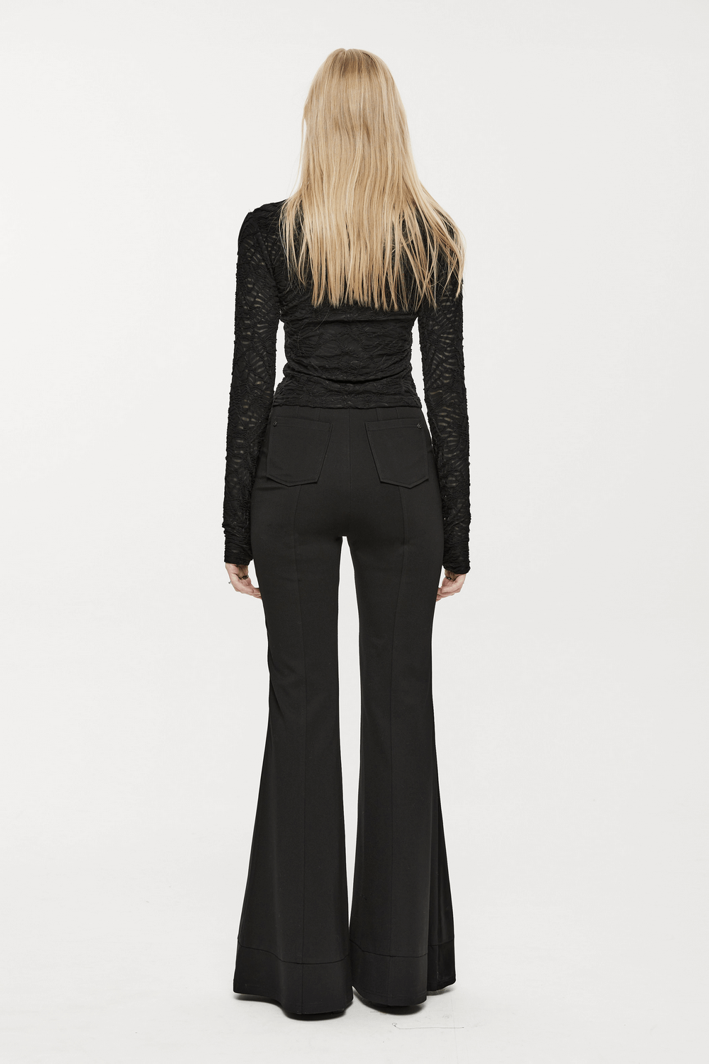 Back view of model wearing high-waisted gothic flare pants with edgy details and sleek black fabric.