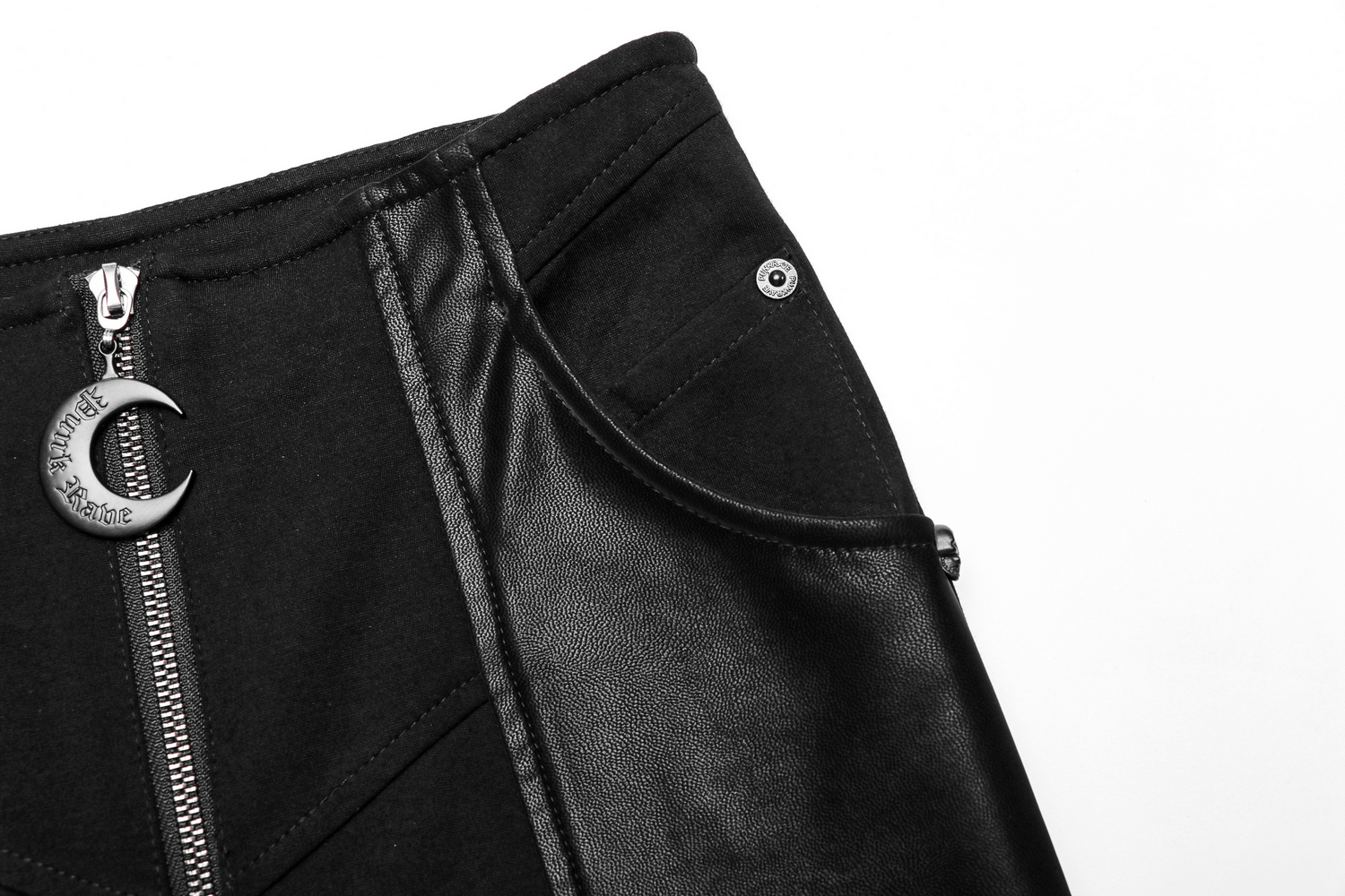 Close-up of high-waisted black flare pants with zipper and punk-style crescent pendant.