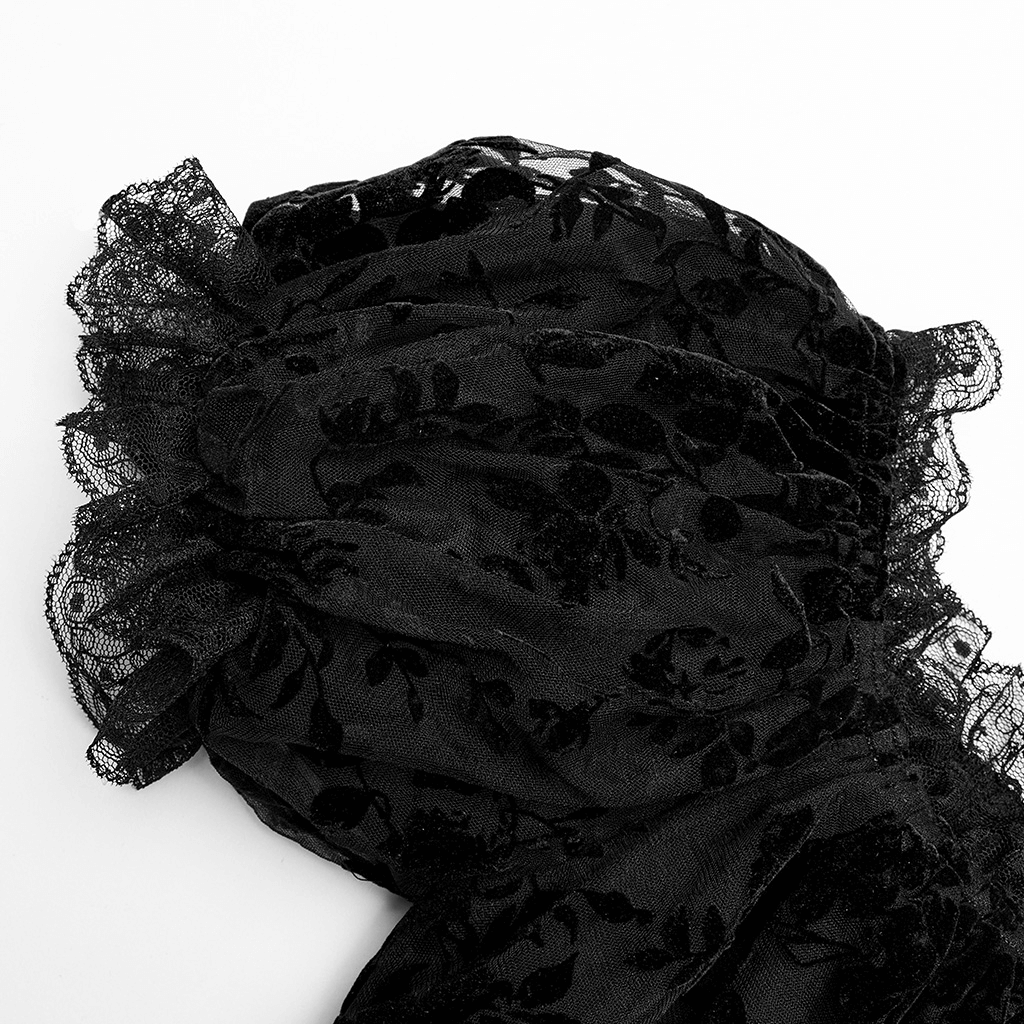 Close-up of a soft black flocked mesh fabric with lace trim, showcasing gothic elegance and intricate design details.
