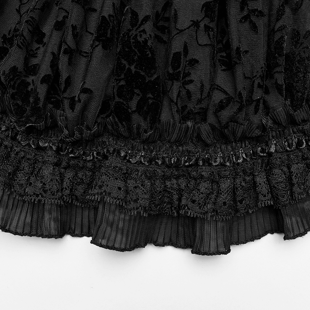 Close-up of a black flocked mesh fabric with delicate lace edges and elastic ruching, showcasing gothic elegance.