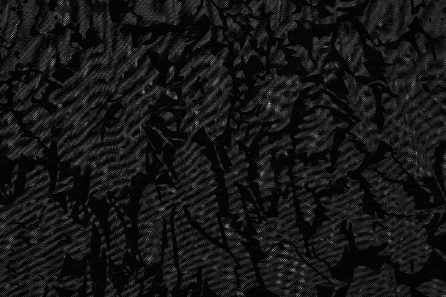 Close-up of floral flocked mesh fabric in black, showcasing elegant gothic patterns for stylish tops.