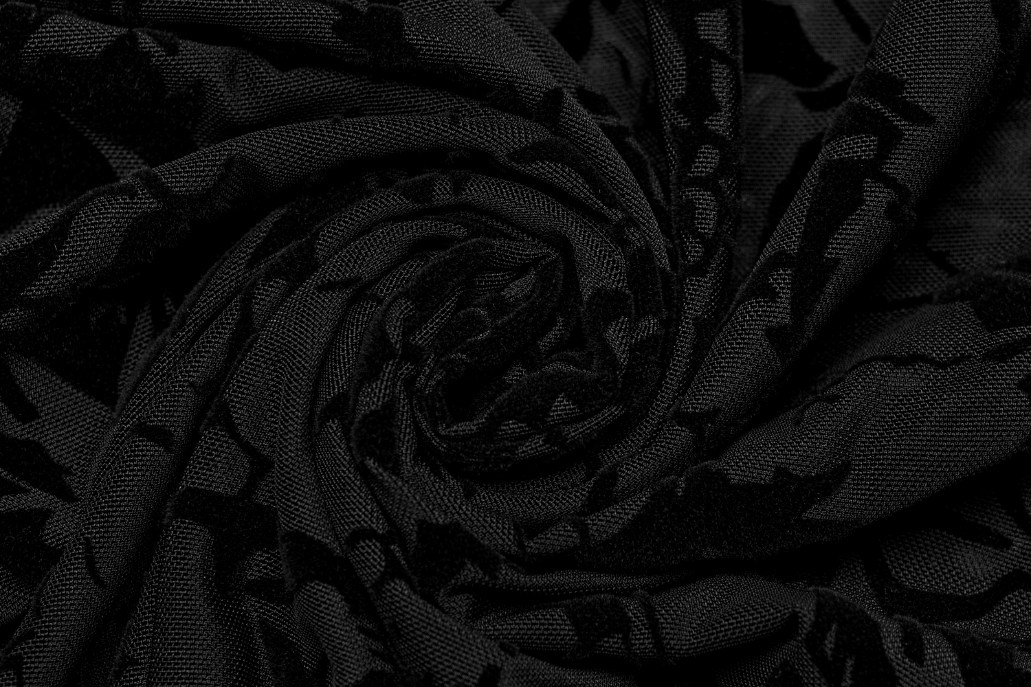 Black floral flocked mesh fabric in a spiral pattern, showcasing elegance and gothic charm for stylish clothing.