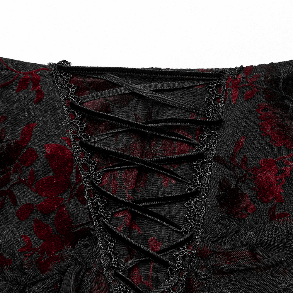 Detailed view of gothic red floral lace design, showcasing intricate lacing on a black fishtail skirt.