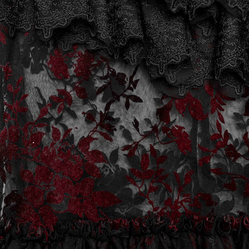 Close-up of floral gothic lace fabric in deep red and black, showcasing intricate patterns and textures.