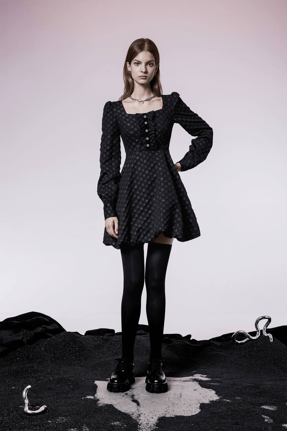 Model wearing a black floral jacquard square-neck dress with button details and wide sleeves.