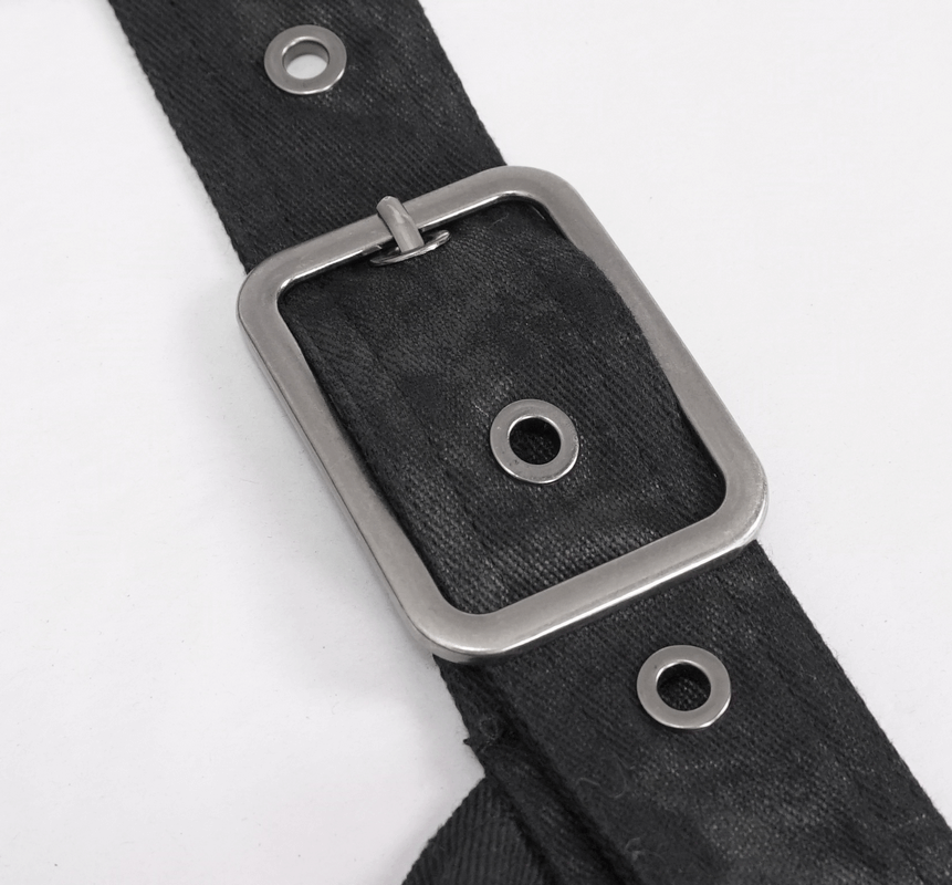 Close-up of a black strap with a silver buckle and grommets, perfect for steampunk and fashionable outfits.