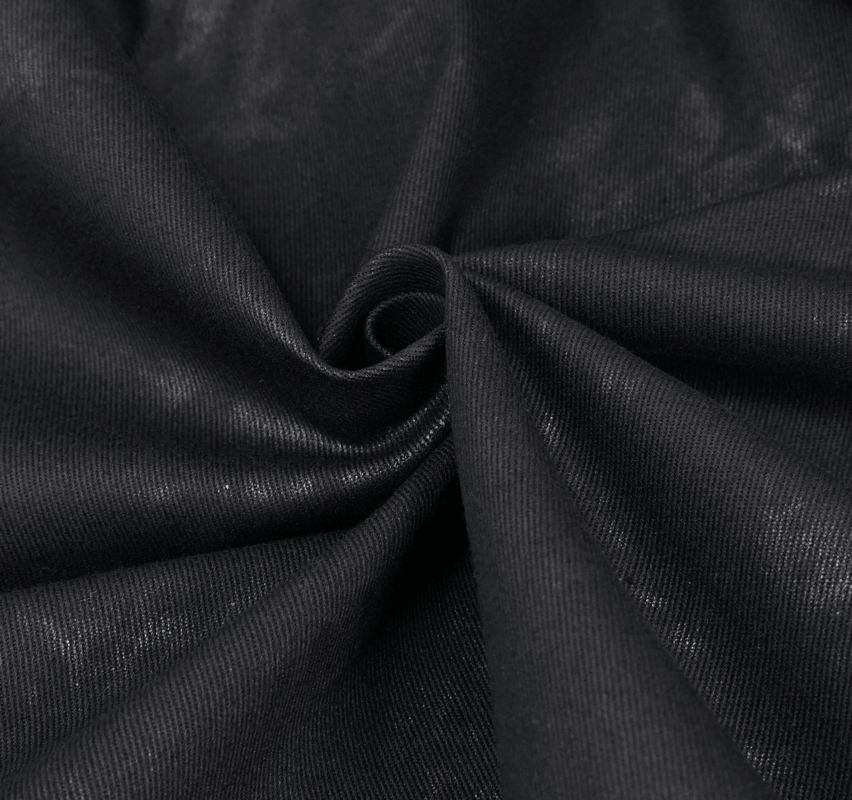 Close-up of soft black fabric showcasing its texture and smooth weave, perfect for garments like kilts and hoodies.