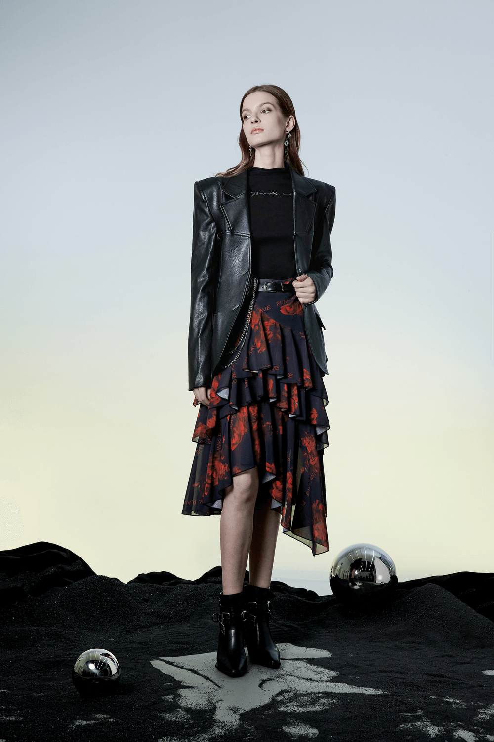 Model in a high-low floral layered skirt with leather blazer showcasing a punk rave style.